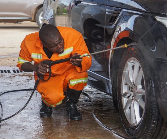 Tonderai Nidza rinses a car in Ruwa, Harare, Zimbabwe on January 23, 2022. The car wash aims to conserve water amid a local shortage. (Vimbai Chinembiri/Global Press Journal)