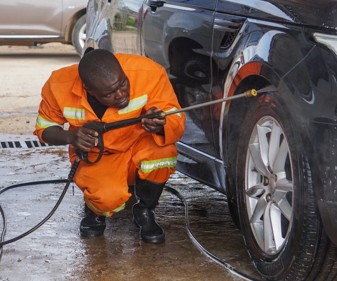 Tonderai Nidza rinses a car in Ruwa, Harare, Zimbabwe on January 23, 2022. The car wash aims to conserve water amid a local shortage. (Vimbai Chinembiri/Global Press Journal)
